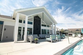 a house with a swimming pool and a patio with chairs at Centennial Crossing, Waukee, 50263